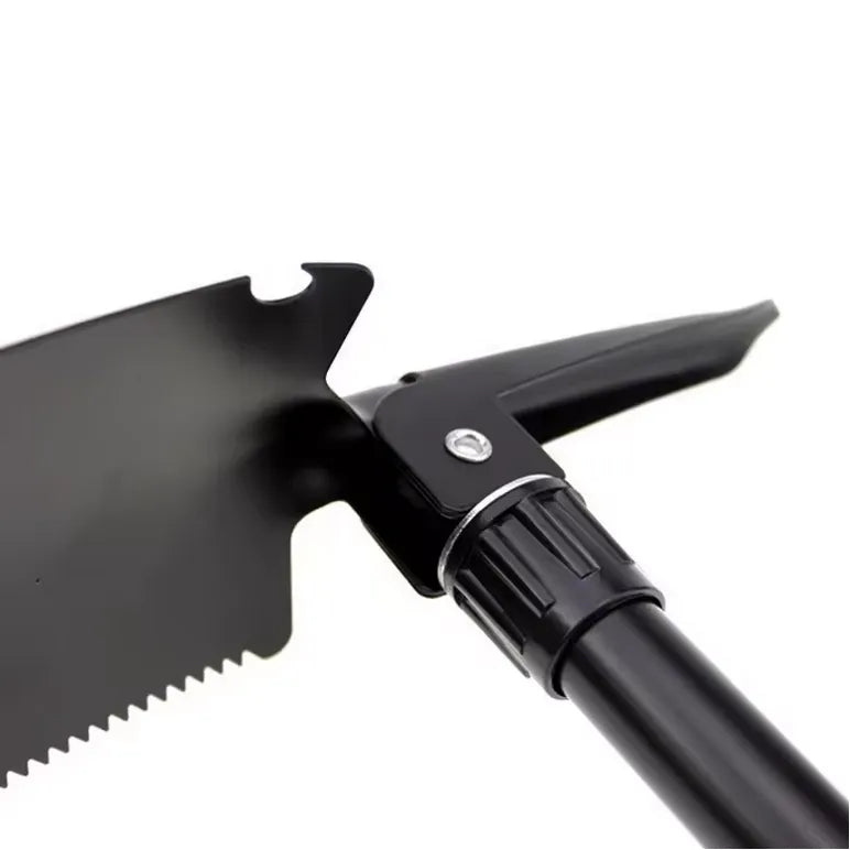 Pelle de survie robuste en acier avec bord denté, pliable et adaptée à la randonnée.